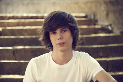 Close-up portrait of young man sitting on steps