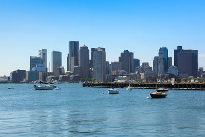 Scenic view of sea and buildings against clear sky