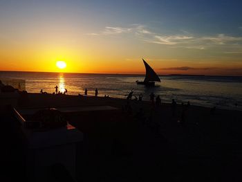 Silhouette person on beach against sky during sunset