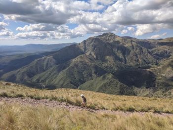 Girl walking on trail against rock mountain