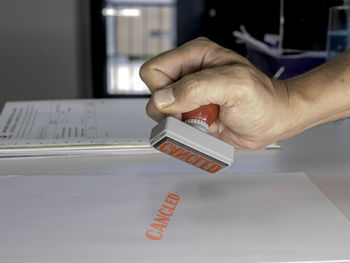 Close-up of hand holding text on paper