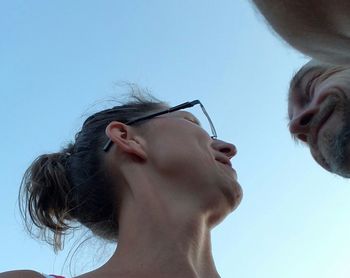 Woman looking away against blue sky