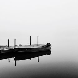 Ship moored on shore against clear sky