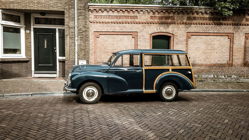 Vintage car parked on street against building