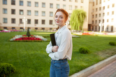 Portrait of smiling young woman standing outdoors