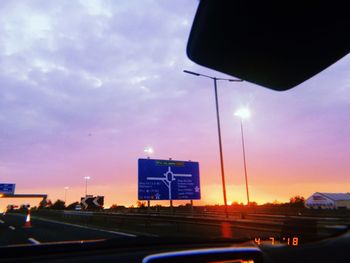 Cars on road against sky during sunset