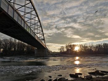 Bridge over river against sky during winter