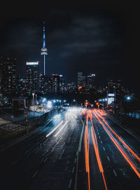 High angle view of light trails on street amidst buildings at night