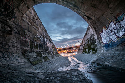 View of arch bridge against cloudy sky