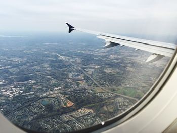 Cropped image of airplane flying over cityscape