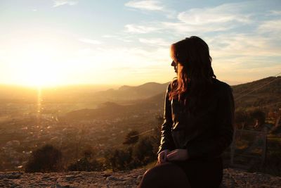 Woman looking at mountains against sky