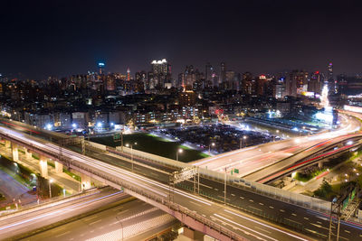 High angle view of illuminated city street and buildings at night