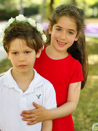 Portrait of smiling friends standing on field
