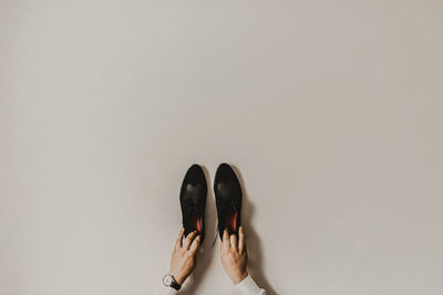 Low section of woman standing against wall