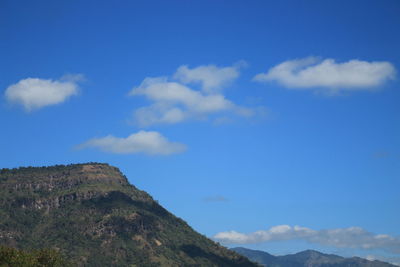 Low angle view of mountain against blue sky