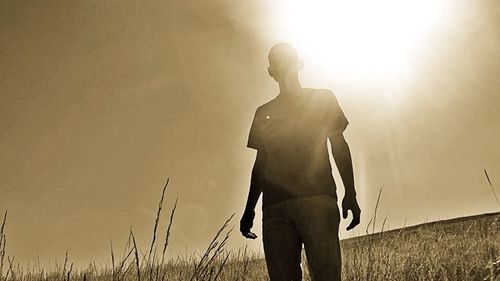 Silhouette of woman standing at sunset