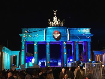 People in illuminated traditional building at night