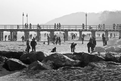 View of people standing on rocks at sea