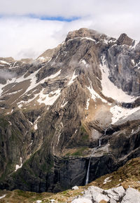 Scenic view of mountain range against cloudy sky