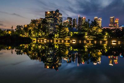 Reflection of buildings in lake at night