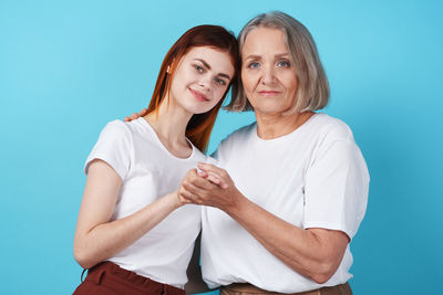 Portrait of young woman against blue background