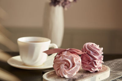 Aesthetic tender dessert - marshmallows with currant and cup of black tea. autumn cozy breakfast