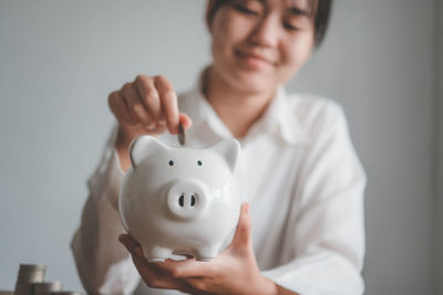 Midsection of woman holding piggy bank