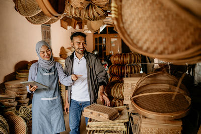 Portrait of smiling couple standing in wicker basket