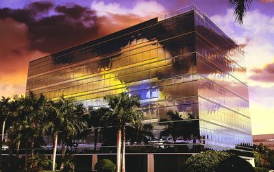 Low angle view of modern building against cloudy sky