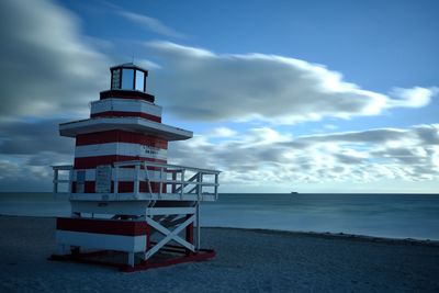 Lifeguard hut on beach against sky