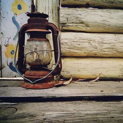 Close-up of rusty padlock on wooden wall