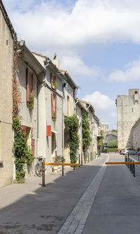 Houses by street in town against sky