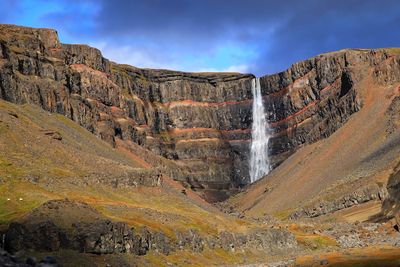 Scenic view of waterfall against sky