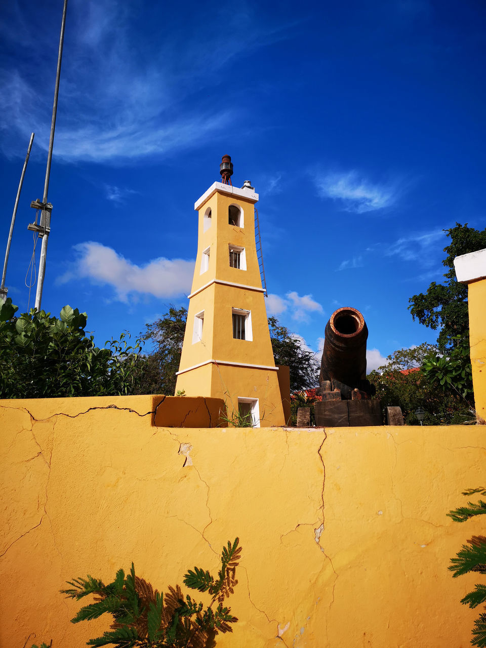 LOW ANGLE VIEW OF YELLOW TOWER AGAINST SKY