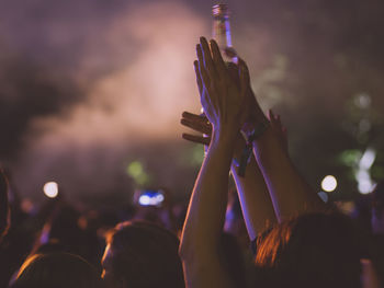 Crowd at music concert against sky at night