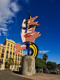 Low angle view of sculpture against blue sky