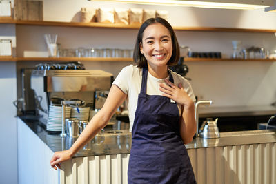 Portrait of smiling young woman standing in city