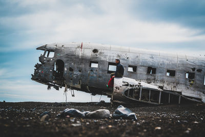 Abandoned airplane on airport runway against sky