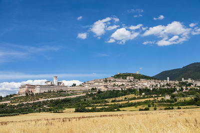 Built structure on landscape against blue sky