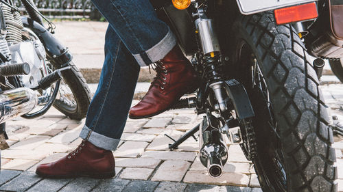 Low section of man standing on motorcycle