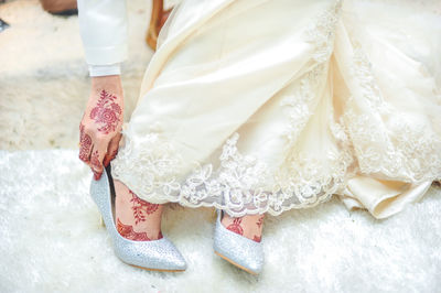 Low section of woman wearing shoes during wedding