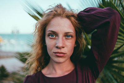 Close-up portrait of young woman with hand in hair