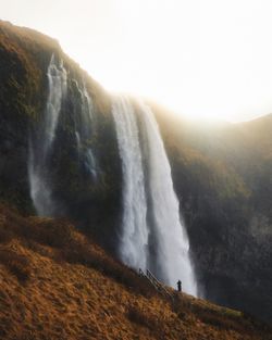 Scenic view of waterfall against sky