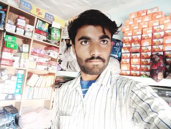 Portrait of young man standing in store