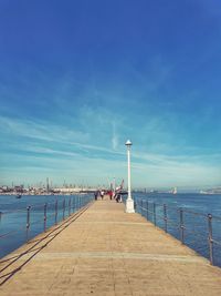 Pier over sea against blue sky