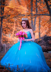 Smiling bride sitting against plants