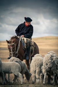 Man riding hat on land against sky