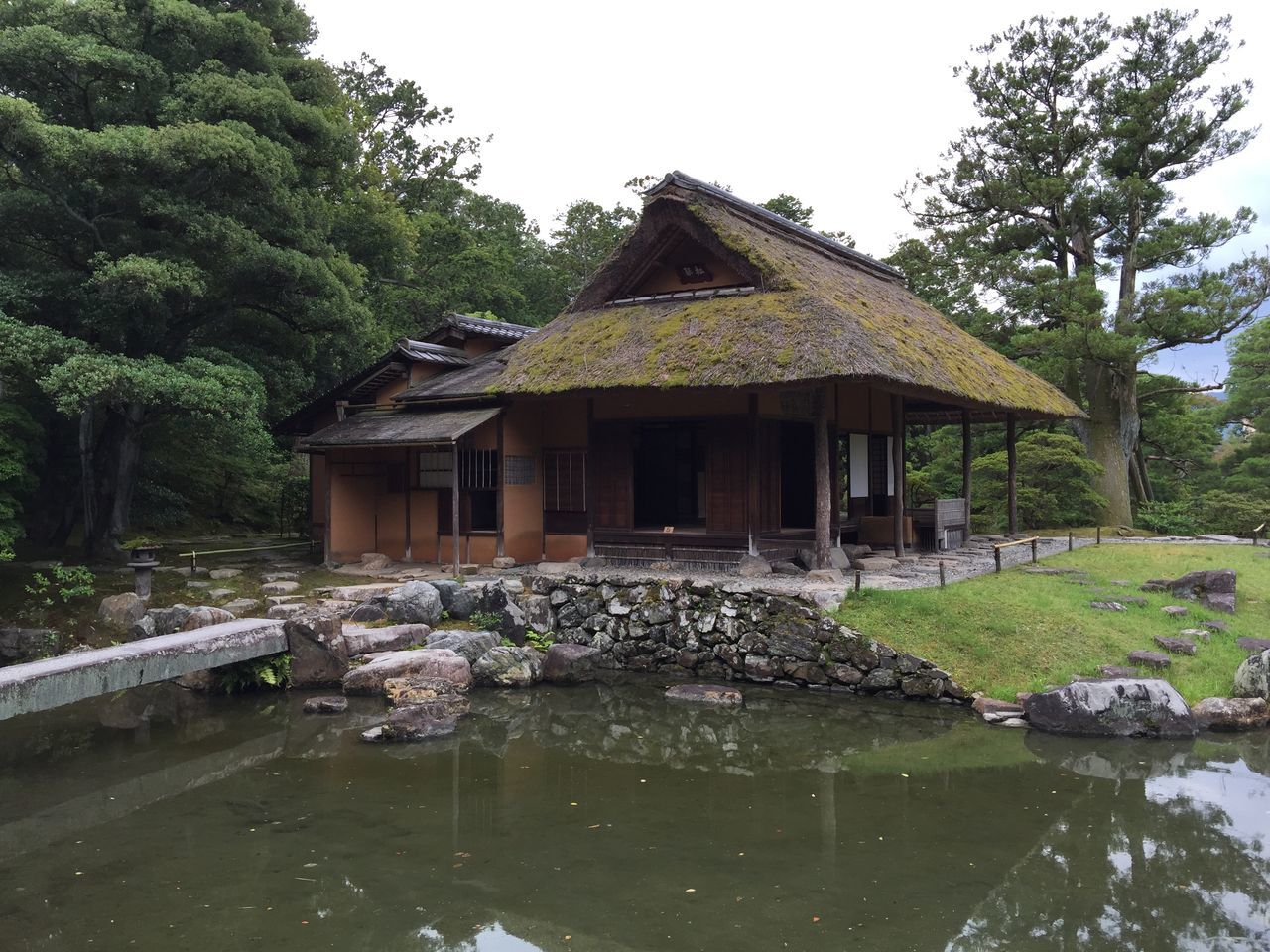 architecture, built structure, building exterior, water, house, tree, residential structure, waterfront, sky, clear sky, day, river, nature, plant, reflection, lake, outdoors, residential building, no people, village