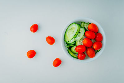 High angle view of cherries in bowl against white background