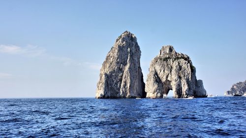 Scenic view of rock formation in sea against sky